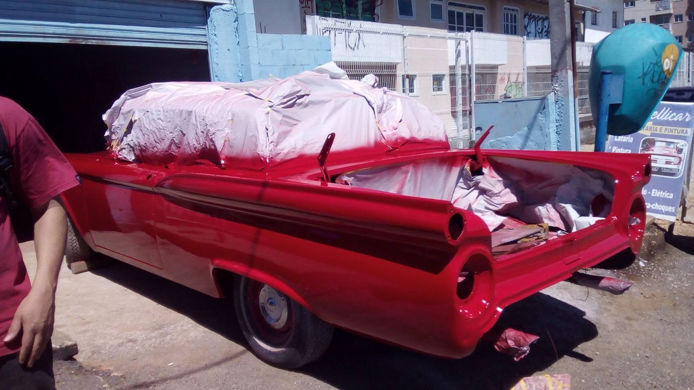 Ford clássico vermelho com rabo de peixe na fase de pintura