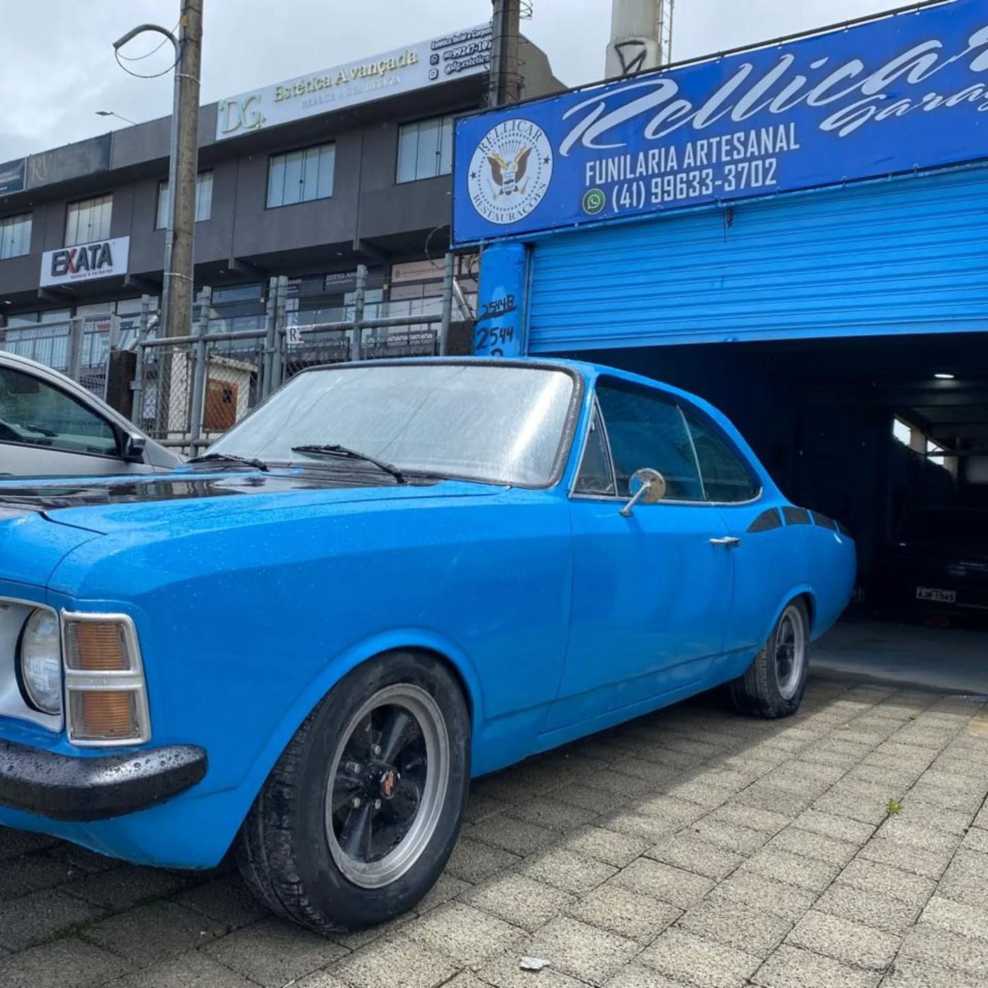 Chevrolet Opala azul em frente à oficina Rellicar